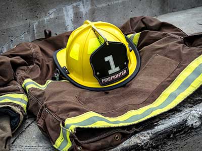 a fire-fighter uniform on the floor. There is also the classic yellow helmet.